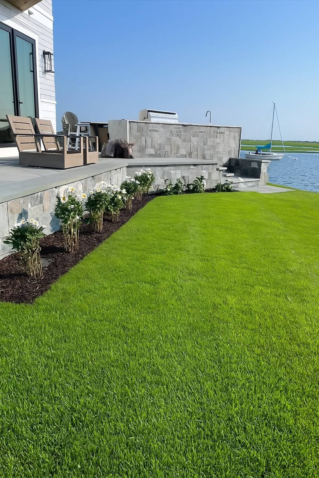 Waterfront residential lawn and stone terrace on Cape Cod — residential landscaping by Hynes